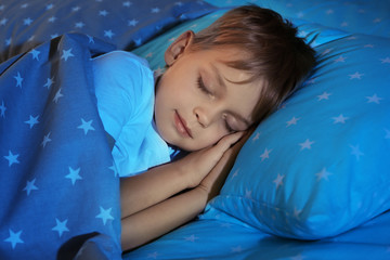 adorable little boy sleeping in bed