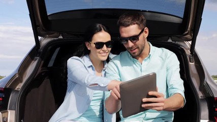 Poster - happy couple with tablet pc at hatchback car trunk 6