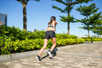 Back view of woman running in a park