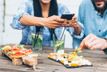 Young Couple Sitting In The Restaurant And Taking Pictures Of The Food With Mobile Phone