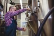 © WavebreakMediaMicro - Manufacturer filling beer from storage tank at brewery