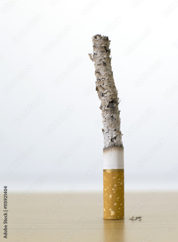 ashing a cigarette cigarette with long ash on wood table backgroud Stock Photo