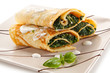Crepes with spinach and feta cheese on white background 