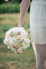 Wall Mural - Bride holding wedding bouquet, bunch of fresh cut flowers.