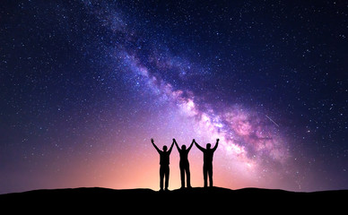 Wall Mural - night landscape with milky way and silhouette of people. night starry sky with silhouette of happy f