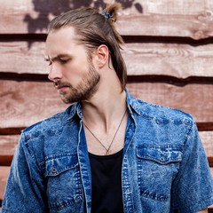 Wall Mural - Portrait of young handsome man against wooden wall.