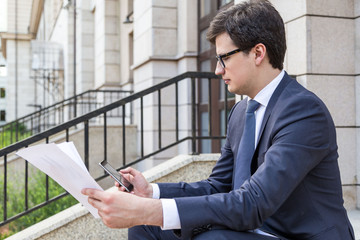 Canvas Print - Man with paperwork using phone