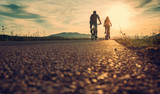 Fototapeta  - Cyclists are on the sunset road