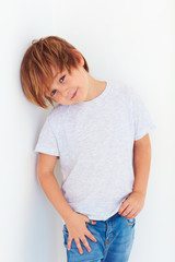 handsome young boy, kid posing near the white wall