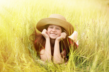 Wall Mural - Sweet girl in meadow with wild spring flowers