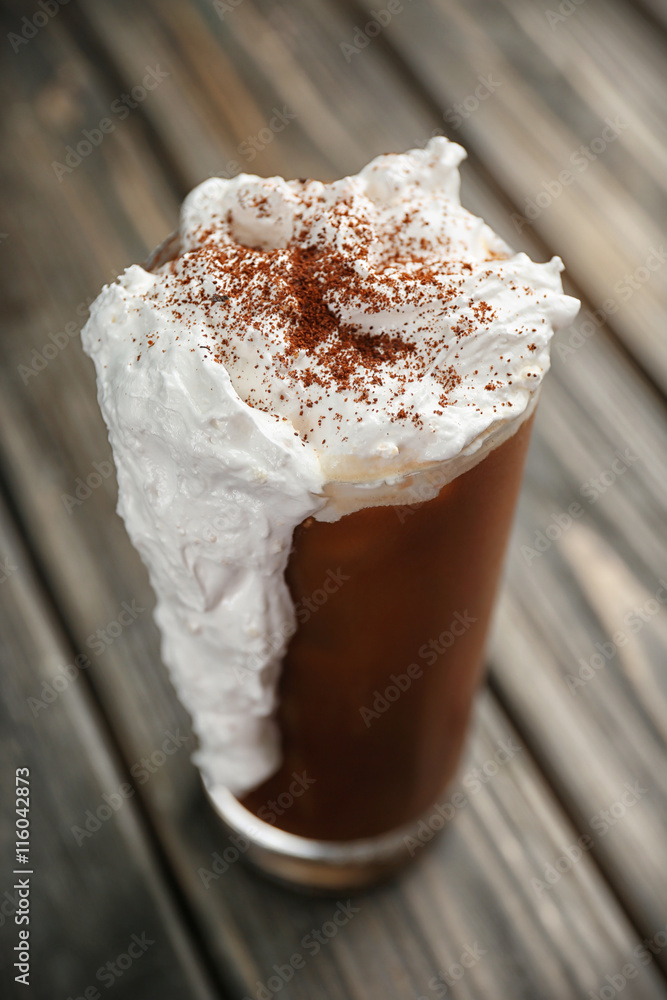 Iced coffee with cream on wooden table