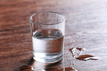 Wall Mural - Filled glass of water on wooden background