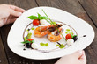 © golubovy - Plate with grilled shrimps taking from dark wooden table close-up, seafood meal cooking