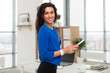 © undrey - Portrait of businesswoman in office looking confident and smiling.