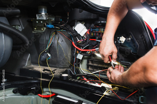 Electrician works with electric block in car Poster Mural XXL