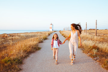 Child with mom walking on the beach