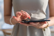 © undrey - Close-up photo of a businesswoman with digital tablet in hands. Female  typing, texting and messaging, using wireless internet connection.
