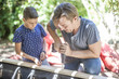 © Westend61 - Father and son building a sandpit in garden together