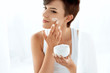 © puhhha - Beauty Skin Care. Beautiful Woman Applying Cosmetic Face Cream