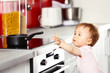 © Africa Studio - Little child playing with pan and electric stove in the kitchen