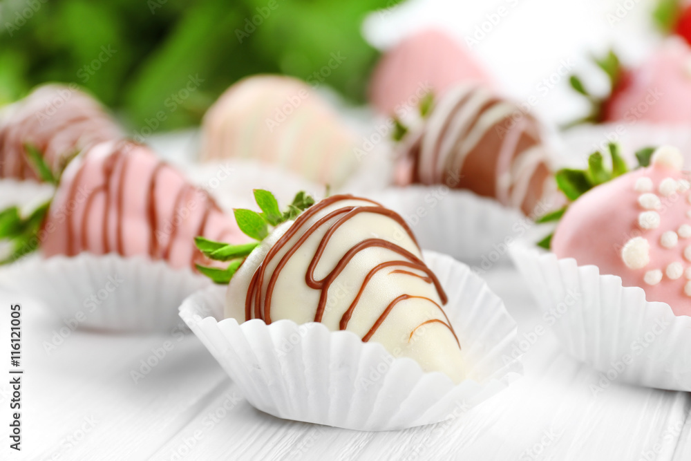 Tasty strawberries in chocolate on light wooden table