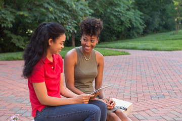 2 african american college students looking at a tablet