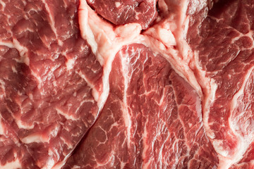 Fresh steak on marble background. Uncooked beefsteak cooking on a kitchen. Delicious, spicy, juicy meat with copy space closeup.