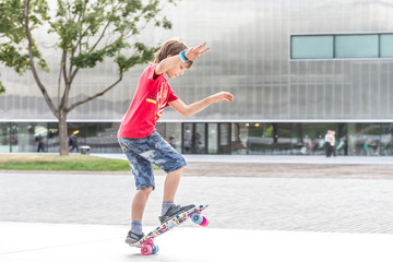 outdoor portrait of young smiling teenager boy riding short mode