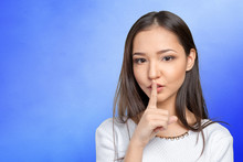 Portrait Of Attractive Teenage Girl With Finger On Lips