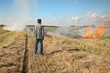 © sima - Farmer looking to fire in field after harvest of wheat