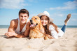 © Drobot Dean - Happy young couple hugging with dog on the beach