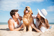 © Drobot Dean - Couple lying and having fun with dog on the beach