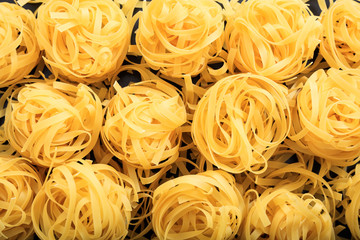 Full background of raw tagliatelle pasta