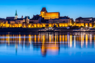 Torun Old Town at night reflected in Vistula river, Poland