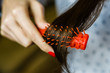 Young brunette woman combing her brown hair. Selective focus.
