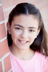 Wall Mural - Preteenager girl next to a red brick wall