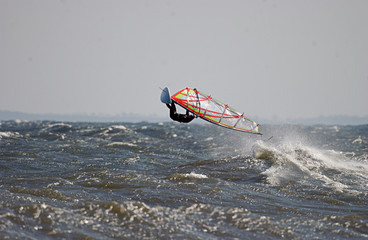 windsurfer bei Sturm macht einen hohen Luftsprung