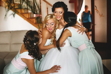 Wall Mural -  Bridesmaids embracing a charming bride