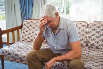 Wall Mural - sad senior man sitting on a couch