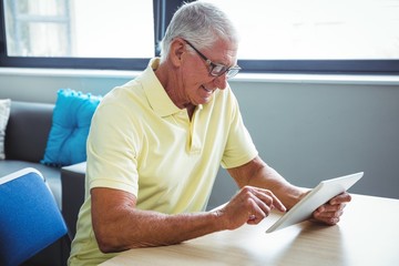 Wall Mural - senior man using a digital tablet