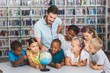 © WavebreakmediaMicro - Pupils and teacher looking at globe in library