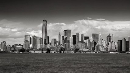Wall Mural - Black & White time lapse of New York City’s Financial District skyscrapers and clouds with Ellis Island from New York harbor