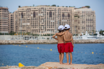 Canvas Print - Two boys on the beach, having fun on a rock pier