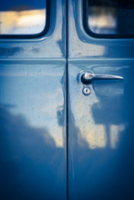 Ancient Van Door Detail / Closeup Of Locked Blue Oldtimer Car Back Door With Windows, Lock And Door Handle In Mysterious Vintage Light With Reflections On It