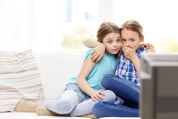 Wall Mural - scared little girls watching horror on tv at home