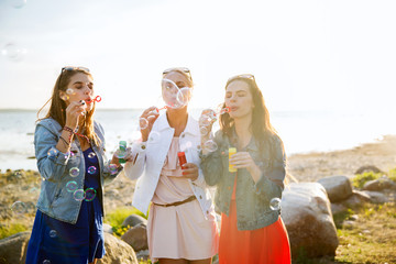 Canvas Print - young women or girls blowing bubbles on beach