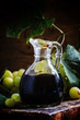 Balsamic vinegar in a glass jug, vintage wooden background, rust