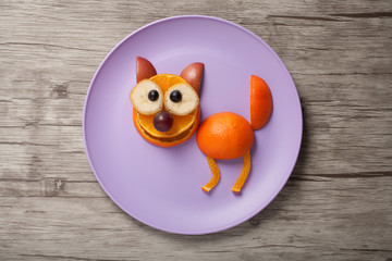 Cat made of fruits oo plate and wooden desk