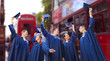 group of happy students waving mortarboards