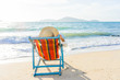 © Netfalls - Young woman in hat sitting on beach